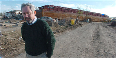 Mark Schleifstein in the Lower Ninth Ward, New Orleans, 2005. In the background is a barge that broke through the breach in the wall of the Inner Harbor Navigation Canal into the neighborhood during Hurricane Katrina, Aug. 29, 2005, crushing the front end of a school bus (far right). Photograph by Ellis Lucia, courtesy of the Times-Picayune. 